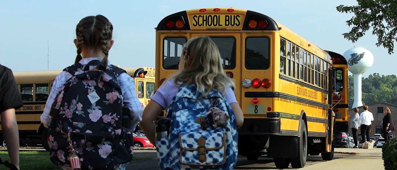 Kids getting off Buses